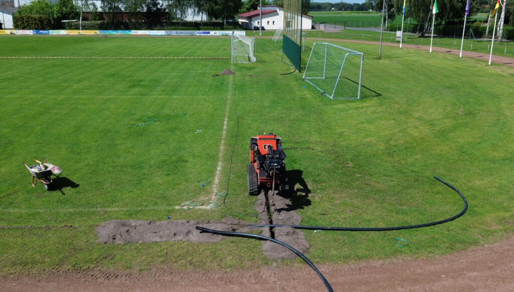 Ditch Witch SK1050 Einzugsmaschine bei der Verlegung der Bewässerungsrohre auf einem Fußballplatz
